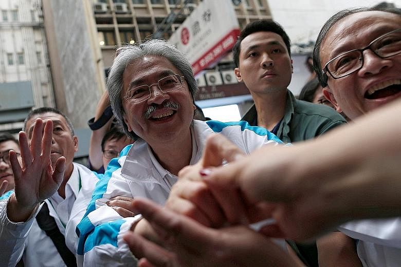 Chief executive candidate Lam signing autographs for her fans on Thursday. The former chief secretary wrote that Hong Kongers should "come together again for the city we love" in an advertisement in the Post yesterday. Chief executive candidate Tsang