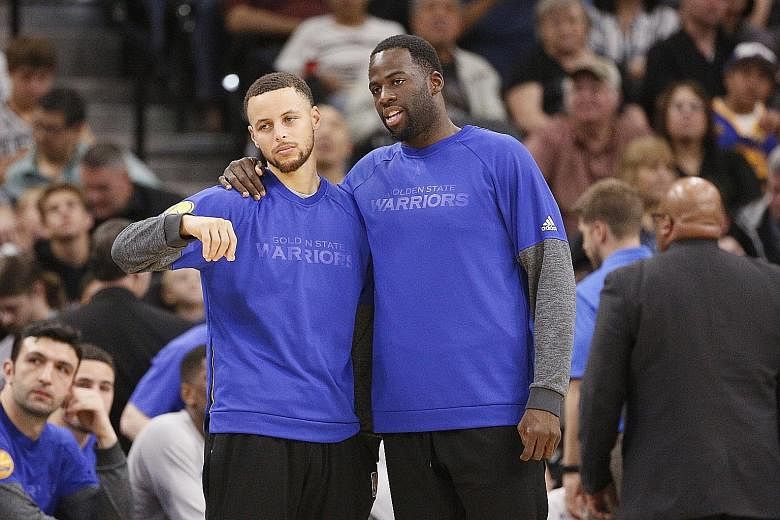 Stephen Curry (far left) and Draymond Green at the sidelines during Golden State's road loss to San Antonio earlier this month. Many coaches are juggling their line-ups to keep the big names fresh for the play-offs.