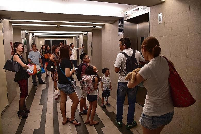 Residents of Block 1E waiting in the lift lobby. From about 9.10am to 10am, and from around 5.30pm to 7.15pm yesterday, residents at the block were left without any lift access at all.