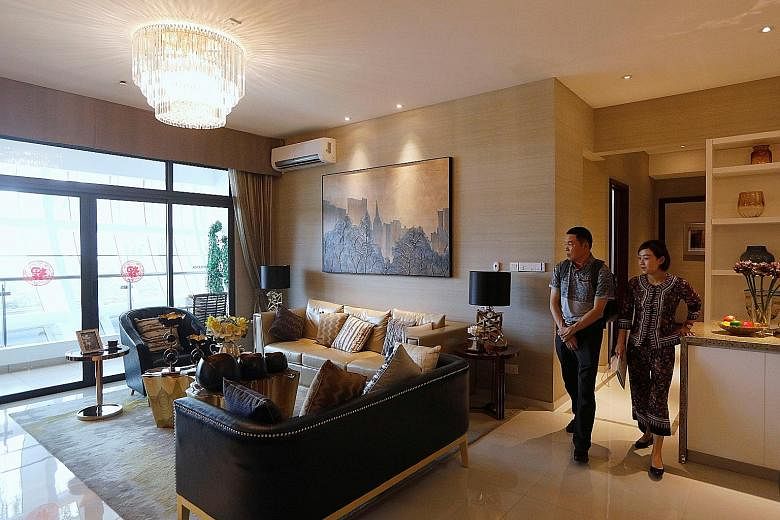 A sales agent taking a prospective buyer on a tour of a show flat at Country Garden's Forest City in Johor Baru. Hundreds of Chinese investors have bought units in the residential project, and they are affected by China's new limits on the ways they 