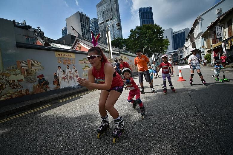 Families and friends at play during a roller blade game at the March edition of the Car-Free Sunday initiative in Amoy Street yesterday. Without cars zooming past, participants could also enjoy an unobstructed view of the work of artist Yip Yew Chong