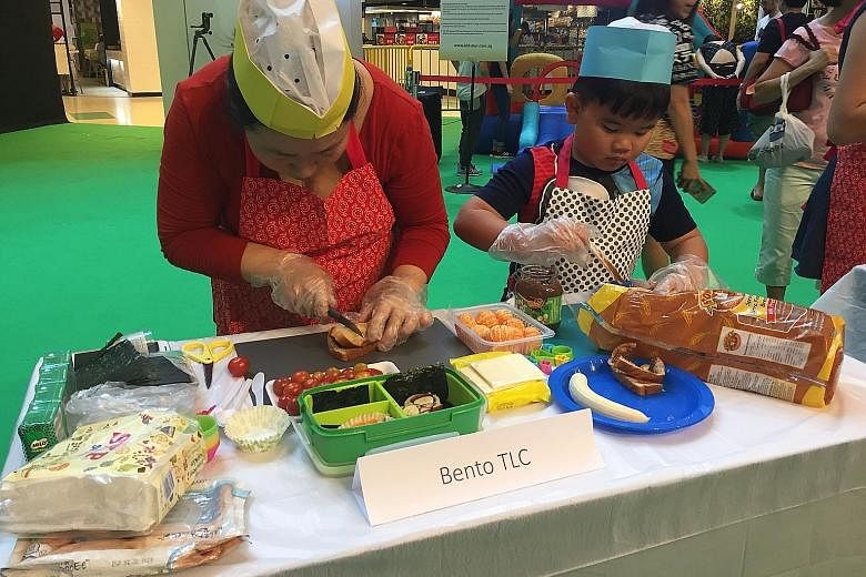 Families taking part in preparing nutritious food in a Healthy Lunchbox competition at United Square yesterday to launch the 10th anniversary of the Cold Storage Kids Run. This year's run will take place on May 28 at Sentosa's Palawan Green, and all 