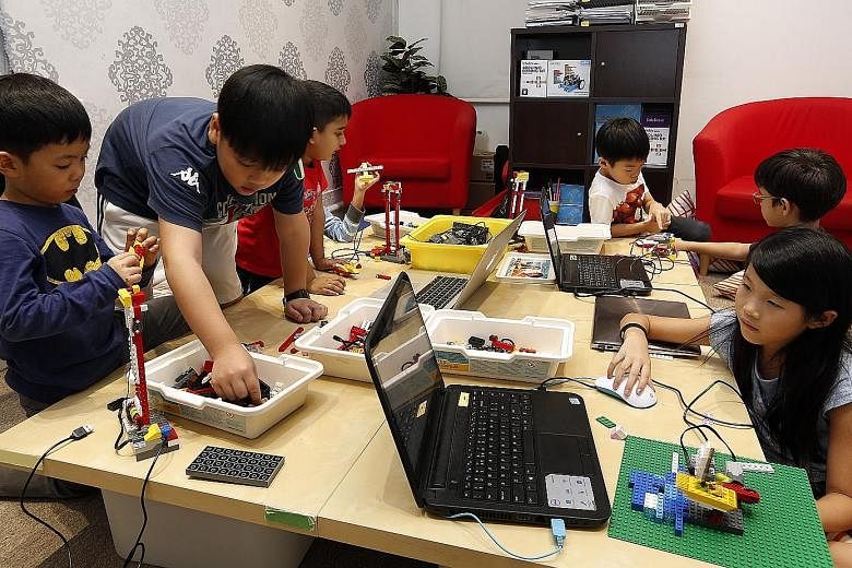 Children learning how to make their own robots using Lego pieces during a holiday workshop on robotics and game design at In3Labs. Robots and computer programs are helping do jobs ranging from delivering room service to providing financial advice, an