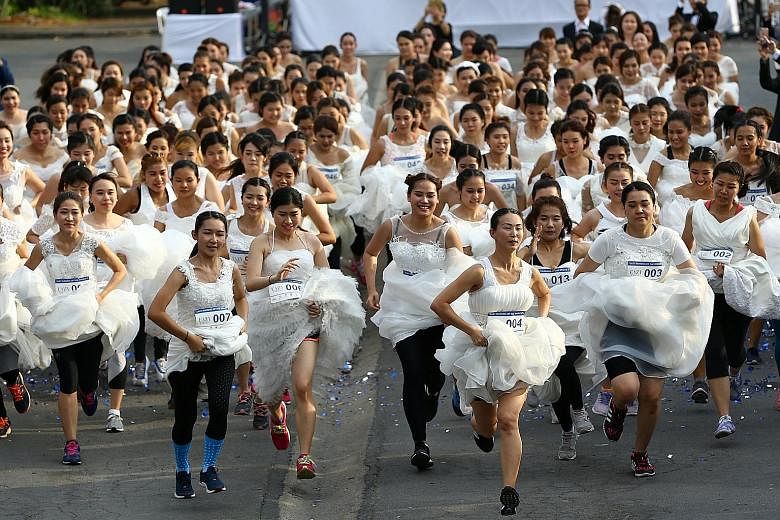 Brides-to-be participating in the annual Running of the Brides race in a park in Bangkok, Thailand, on Saturday. Some 250 couples in wedding dresses and suits were competing for US$28,000 (S$39,200) in wedding prizes. Ms Sirada Thamwanna, 29, said sh