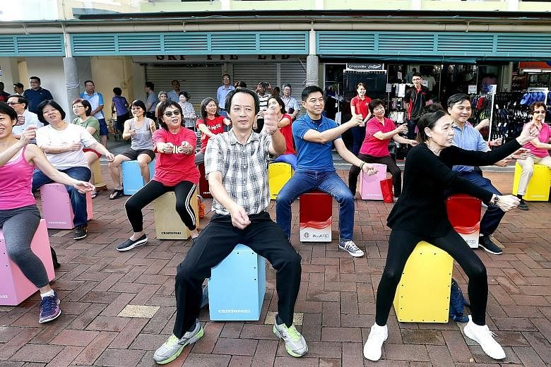 Mr Tan and Mr Saktiandi (both in second row) joining residents in a performance yesterday during a ministerial community visit to Toa Payoh East-Novena ward.