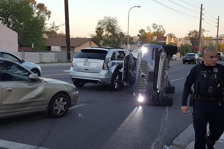 A self-driven Volvo SUV owned and operated by Uber lying on its side after a collision with another vehicle in Tempe, Arizona, flipped it over.