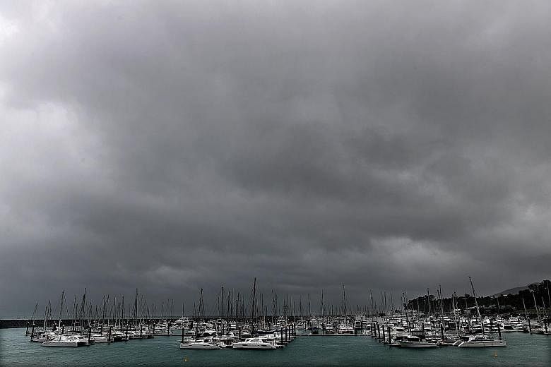 Dark clouds approaching Airlie Beach, Queensland, yesterday as residents in Townsville fill up sandbags in preparation for Cyclone Debbie. The powerful cyclone, packing destructive winds, is expected to hit land after daybreak this morning.