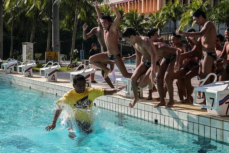 Outram Secondary's water polo boys jump in after pushing their coach Kuah Kar Huat into the pool while celebrating their win in the Schools National B Division boys' final yesterday. Zander Widjaja, Lum Jing Hao, Marc Chew, Ayers Fong and Keefe Law s