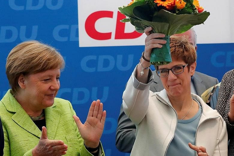 German Chancellor Angela Merkel, who leads the Christian Democrats, applauding the victorious state governor, Ms Annegret Kramp-Karrenbauer, at a party meeting yesterday.