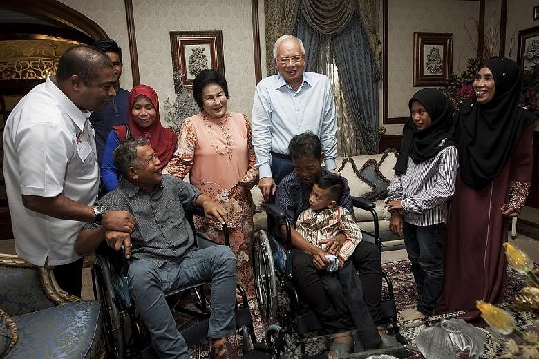 Sailors Abd Rahim Summas and Tayudin Anjut (holding child) and their families meeting Malaysian Prime Minister Najib Razak and his wife Rosmah Mansor at the Premier's residence yesterday. They were held by the Abu Sayyaf for almost a year.