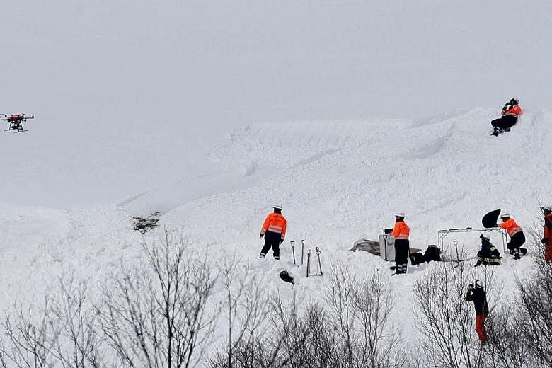 Firefighters and rescue workers using a drone at the site of the avalanche in Japan which killed seven students and an instructor. The tragedy occurred on the final day of a three-day training camp.