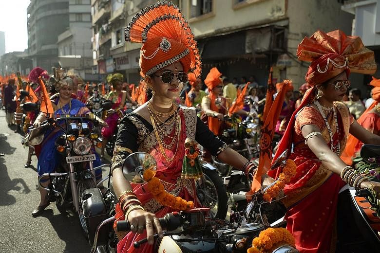 Indian women dressed in traditional attire riding motorcycles in a procession celebrating Gudi Padwa, or the Maharashtrian New Year, in Mumbai yesterday. Gudi Padwa is the Hindu New Year for people in India's Maharashtra state and marks the end of a 