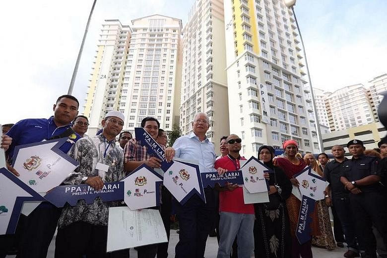 Prime Minister Najib Razak with new owners of flats in Putrajaya built under the civil service housing scheme PPA1M. He handed over 1,680 keys to the homes on Monday.