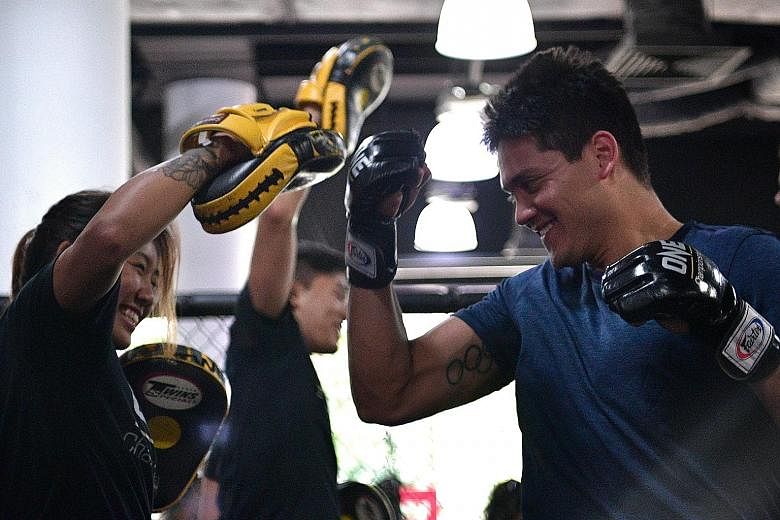 Olympic champion Joseph Schooling tries his hand at mixed martial arts during a training session with One Championship atomweight titleholder Angela Lee last November. He will be in her entourage in May.