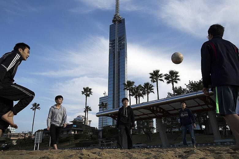A soccer game at a seaside park, with Fukuoka Tower in the background. Fukuoka is the fastest-growing major city in Japan outside of Tokyo. Mr Watabe moved to Fukuoka in 2013 to develop smartphone apps and software that helps anglers find fish and sh