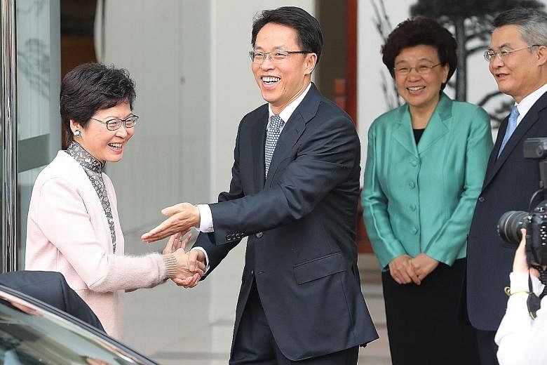 Hong Kong Chief Executive-elect Carrie Lam greeting the director of Beijing's liaison office in Hong Kong, Mr Zhang Xiaoming, during her visit yesterday. Beside them is the office's deputy director Yin Xiaojing. Mrs Lam said Hong Kong has "lost a few
