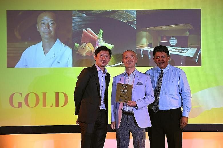 Shinji by Kanesaka's master chef Koichiro Oshino receiving the gold award from Singapore Press Holdings' deputy chief executives Anthony Tan (left) and Patrick Daniel.