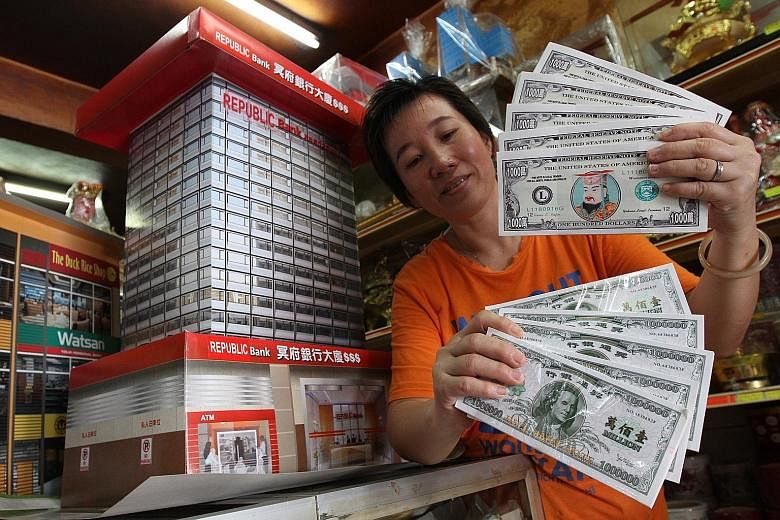 "Hell money" resembling US dollar notes, like the ones shopkeeper Ang Siew Siew sells at her shop in Penang, Malaysia, is in demand. Due to the weakening ringgit, there has been a surge in demand for fake cash - called hell money - resembling strong 