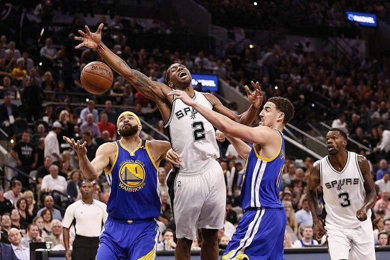 San Antonio small forward Kawhi Leonard is fouled by Golden State shooting guard Klay Thompson at AT&T Centre, as centre JaVale McGee provides cover. The visitors trailed badly but rebounded to win 110-98 and could face the Spurs again in the Western
