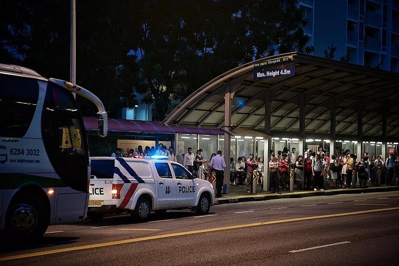 Commuters waiting for free bus services outside Tanah Merah MRT station yesterday evening as train services on the East-West Line between Pasir Ris and Paya Lebar towards Joo Koon were delayed by up to 40 minutes. A police car was stationed there to 
