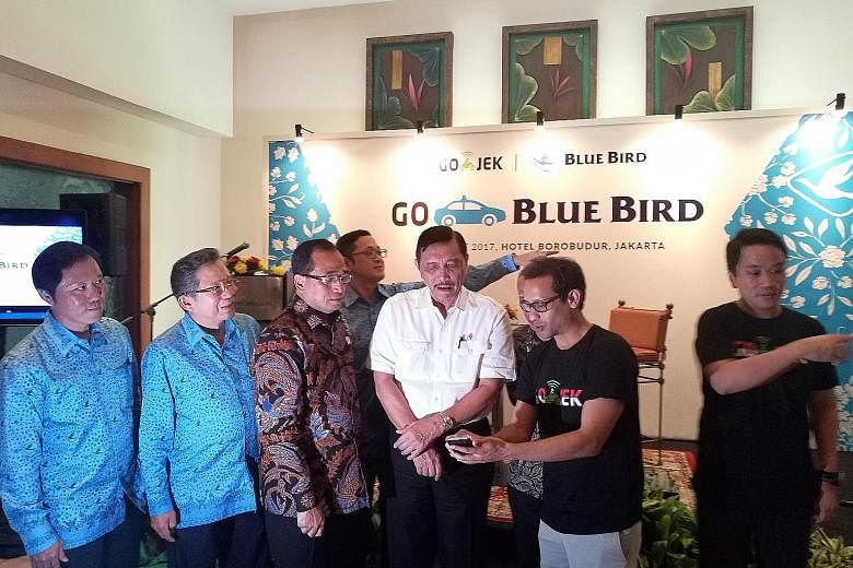 Coordinating Maritime Affairs Minister Luhut Pandjaitan (in white) at the launch of a collaboration between Go-Jek and Blue Bird yesterday. He is flanked by Go-Jek chief executive Nadiem Makarim (in black T-shirt) and Transport Minister Budi Karya. A