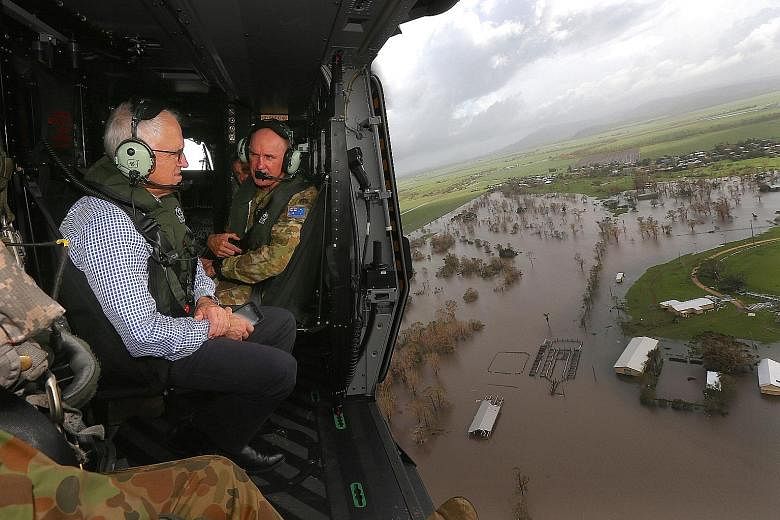 Mr Turnbull surveying the damage caused by Cyclone Debbie near the town of Bowen, south of the northern Queensland town of Townsville yesterday, from aboard an Australian Army helicopter.