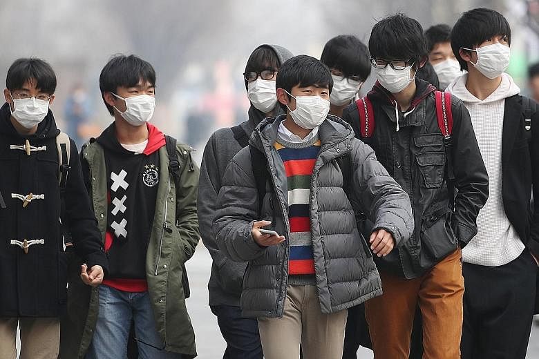 Students in Gwanghwamun Square in central Seoul on Tuesday. The government has issued multiple health warnings over ultra-fine pollutant particles, and local media has reported that sales of portable pollution monitors, face masks and air purifiers h