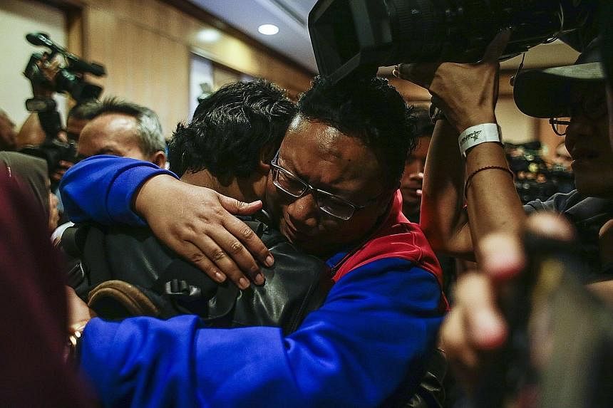 One of the nine returning Malaysian nationals hugging his relative in Kuala Lumpur yesterday.
