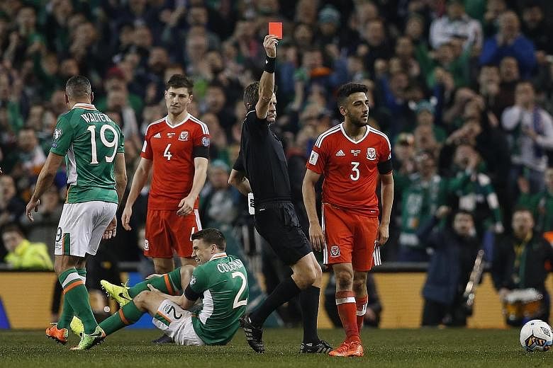 Wales defender Neil Taylor (right) receiving his marching orders after fouling Ireland's Seamus Coleman during a World Cup qualifier. His tackle left the defender with a double leg break.