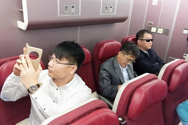 Passengers believed to be North Koreans, including murder suspect Kim Uk Il (far left), in a plane bound for Beijing, at an airport in Kuala Lumpur on Thursday.