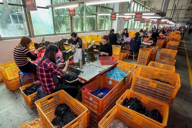 Workers at a shoe factory in China, which enjoys the largest trade surplus with the United States. However, in Beijing yesterday, officials sought to downplay trade tensions with Washington.