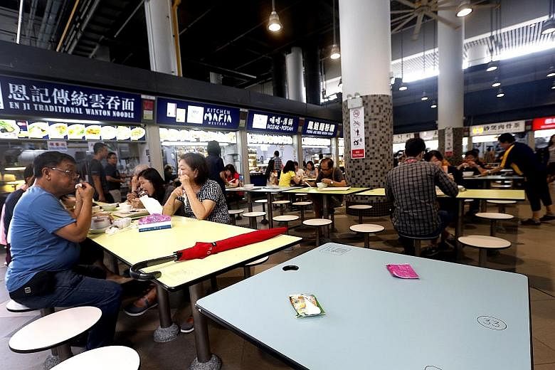 Above, from left: Diners chope seats with items like umbrellas, work passes and water bottles. These pictures were taken at the food centre at Our Tampines Hub which, ironically, has introduced a set of "house rules" on seat-choping.