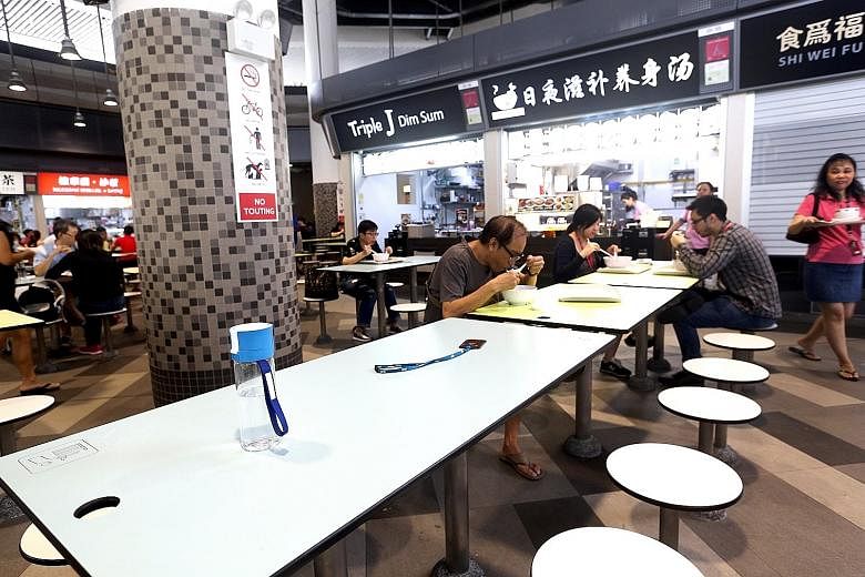 Above, from left: Diners chope seats with items like umbrellas, work passes and water bottles. These pictures were taken at the food centre at Our Tampines Hub which, ironically, has introduced a set of "house rules" on seat-choping.