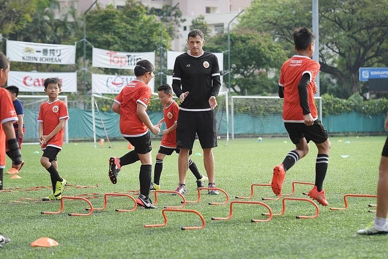 Former national striker Aleksandar Duric, the principal of the ActiveSG football academy, offering encouragement to youngsters at Jurong East yesterday. A year since it opened its doors, the academy has 716 pupils on its books.
