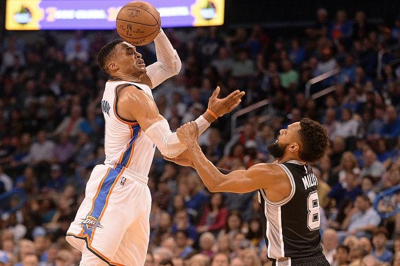 Coming to grips with the challenge of keeping Russell Westbrook at bay, Patty Mills of the San Antonio Spurs fouls the Oklahoma City Thunder guard during the Spurs' 100-95 victory.