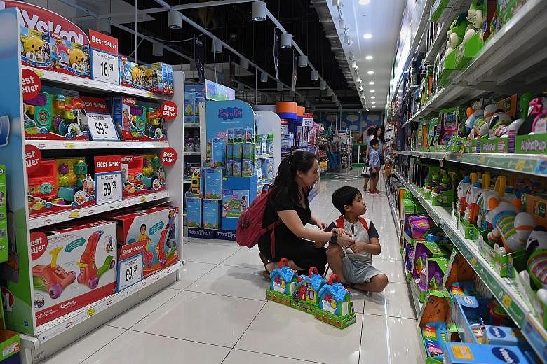 Ms Teo with her son Xander at VivoCity's Toys 'R' Us store yesterday. The store opened earlier at 9am, dimmed its lights and switched off the public address system and some display monitors, among other steps taken to create a more conducive environm
