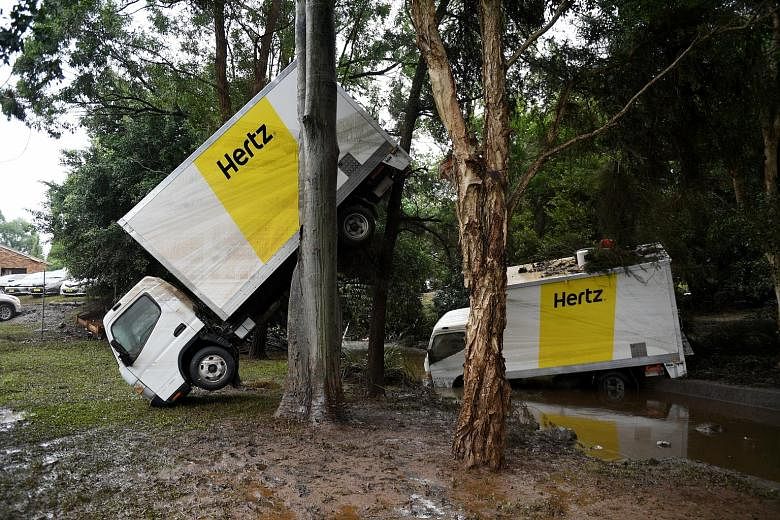 Vans found stranded in a creek after flood waters receded in Lismore, New South Wales, yesterday. Despite being around 1,500km away from the eye of Cyclone Debbie which struck Queensland state last week, Lismore has been inundated with rain and flood
