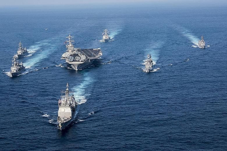 The three US warships - with the USS Wayne E. Meyer in the lead, followed by the USS Carl Vinson and USS Lake Champlain - flanked by Japanese destroyers in an exercise. The US warships visiting Singapore are part of the US Navy's Carrier Strike Group
