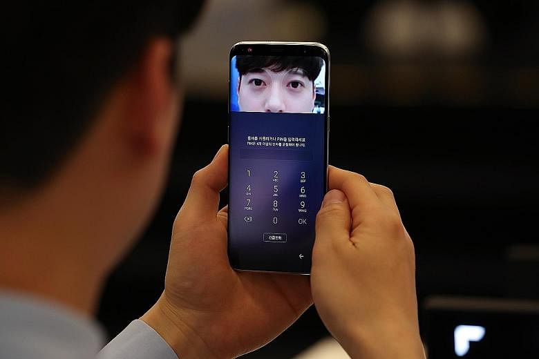 Visitors trying out the Galaxy S8 smartphones at one of the company's promotional booths in Seoul, South Korea, last weekend. The S8 features Bixby, Samsung's own AI-powered virtual assistant software, which sets the firm up in the AI race. The succe