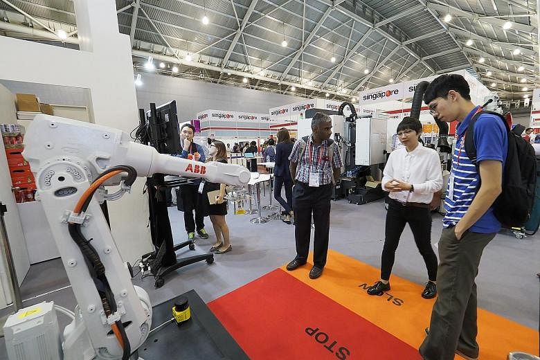 Visitors interacting with technology provider ABB's "collaborative robot" (above), which slows or stops production when it senses operators around it for added safety. An automated guided vehicle by SESTO Robotics (below). Its intelligent software al