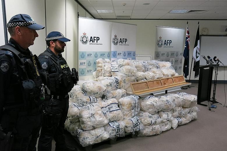 Australian police (left) displaying packs of crystal methamphetamine, or Ice, yesterday after removing the drug from planks of wood (above) at a warehouse in Victoria state, in Australia's biggest bust of the party drug with an estimated street value