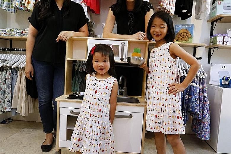 Sisters Carol (far left) and Audrey Ng, founders of children's label Elly, at their store in Cluny Court. With them are Carol's daughters Sophie, seven, and Emelie, three.