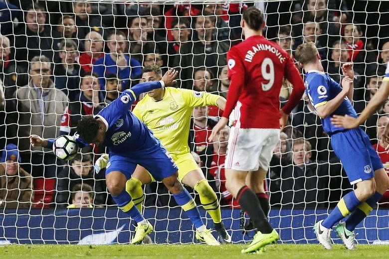 Everton defender Ashley Williams handles the ball in the box after a shot by United's Luke Shaw in an English Premier League match at Old Trafford. Williams was sent off before Zlatan Ibrahimovic converted a stoppage-time penalty to make it 1-1. 