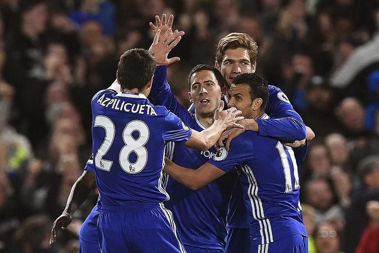 Above: Chelsea forward Eden Hazard (centre) celebrates after scoring against Manchester City. The Belgian recorded his 12th and 13th goals of the season on Wednesday.