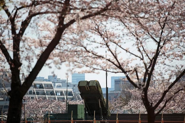 A PAC-3 surface-to-air missile launcher unit, used to engage incoming ballistic missile threats, seen through cherry blossoms at the Defence Ministry in Tokyo on Wednesday.
