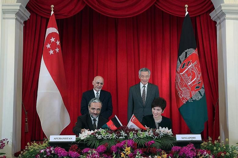 Prime Minister Lee Hsien Loong and Afghan President Mohammad Ashraf Ghani witnessing the signing of the MOU by Mrs Josephine Teo, Senior Minister of State, Prime Minister's Office, Ministry of Foreign Affairs and Ministry of Transport; and Afghan Min