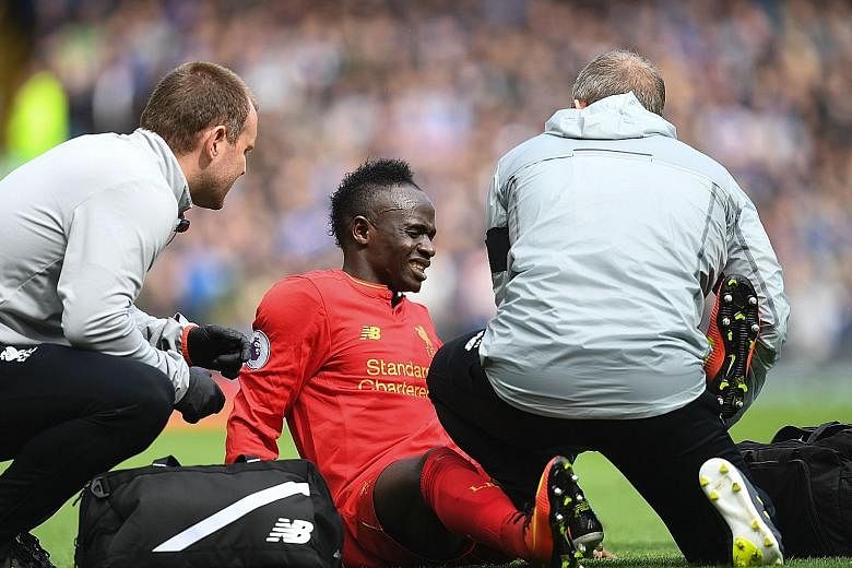 Liverpool forward Sadio Mane receiving treatment on his knee after getting involved in a challenge with Everton's Leighton Baines. Mane's absence for the rest of the season will be a massive blow to the Reds' top-four hopes.