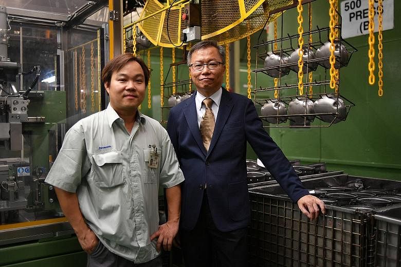 Panasonic employees Ng Wee Teck (left) and Khoo Chew Thong were lauded by Minister for Manpower Lim Swee Say for upgrading their skills to keep up with advances in technology.