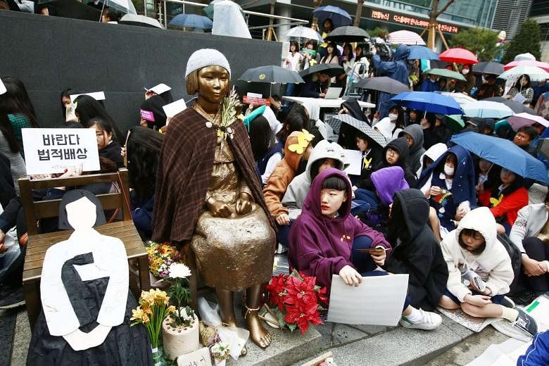 Protesters surrounding a statue symbolising the plight of comfort women at a rally near the Japanese Embassy in Seoul on Wednesday. Japan wants South Korea to remove a similar statue installed in Busan.