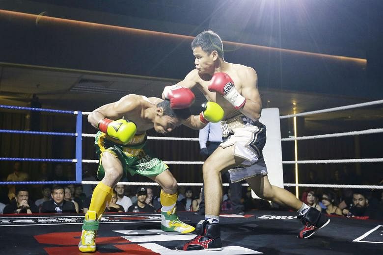 Singapore's Muhammad "The Chosen Wan" Ridhwan (right) in action against Indonesia's Waldo Sabu during the Singapore Fighting Championship 5: Combat Redefined event last night. He became the first Singaporean to win the World Boxing Association (WBA) 